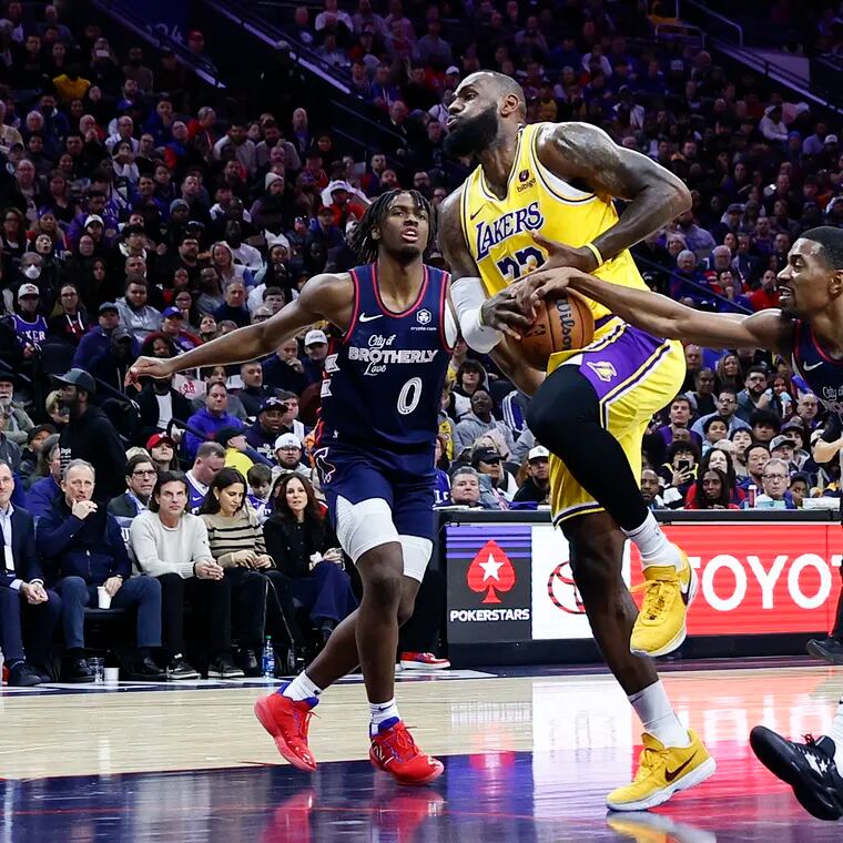 Lakers forward LeBron James loses the basketball driving to the basket against Sixers guard De'Anthony Melton and guard Tyrese Maxey in the third quarter.