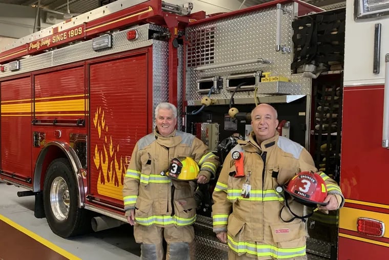 Pastor Tom McGill (left) and Father Dave Driesch at Paoli Fire Company, where they are both volunteer chaplains and firefighters.