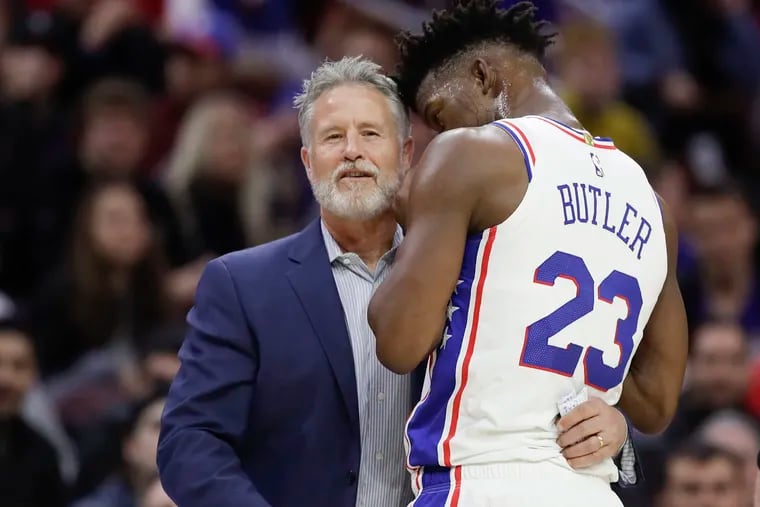 Sixers Head Coach Brett Brown smiles listening to guard Jimmy Butler.