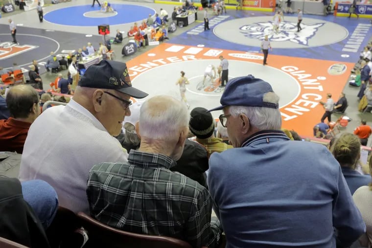 Fred Ulmer (left) Gordon Webster (middle) and Bert McGann (right) discuss wrestling at PIAA Wrestling Quarterfinals at Giant Center in Hershey on Friday.