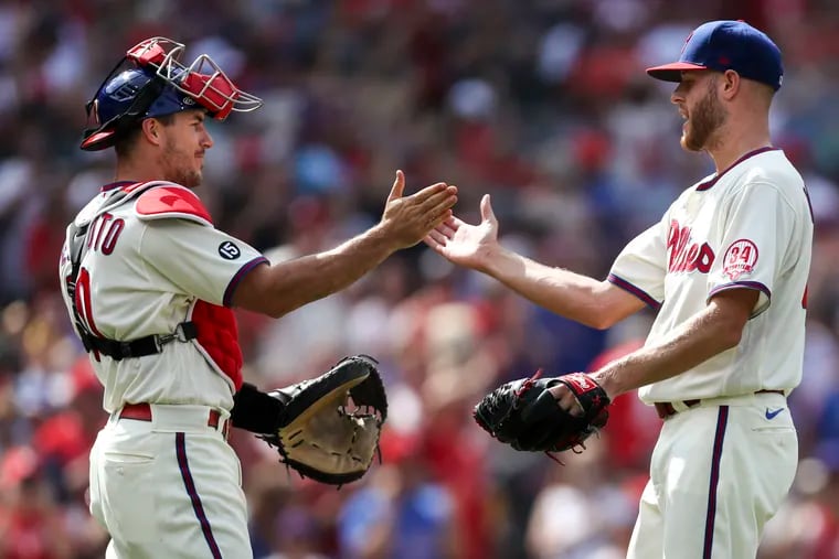 Philadelphia Phillies catcher J.T. Realmuto (10) and starting pitcher Zack Wheeler (45) celebrate after Wheeler pitched a shutout during the Philadelphia Phillies game against the New York Mets at Citizens Bank Park in Philadelphia, Pa. on Sunday, August 8, 2021.  The Phillies won 3-0.