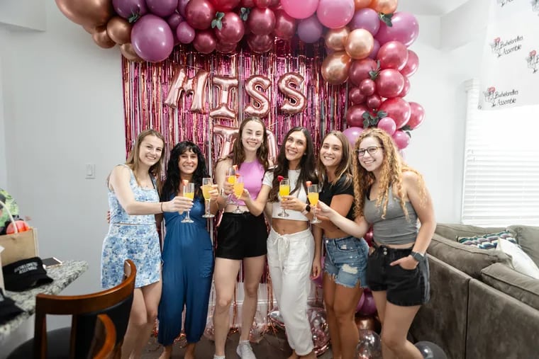 Emily DiGiorgio, in white, poses with her bridal party in front of decorations prepared by the Cape May bachelorette planning company Crash the Cape.