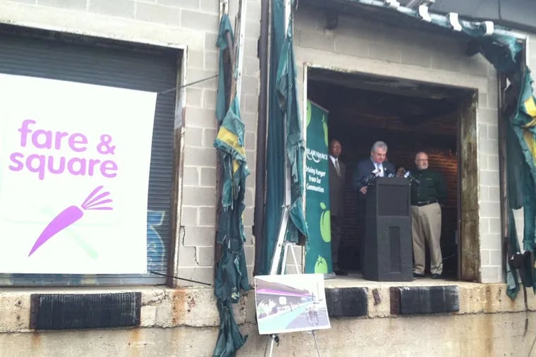 U.S. Rep. Bob Brady at a lectern on the loading dock of a closed supermarket in Chester City, the site of a new market.