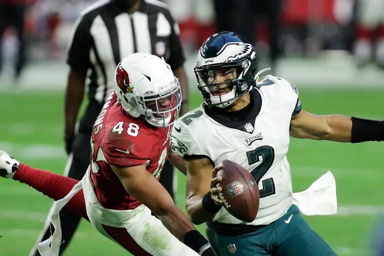 Eagles quarterback Jalen Hurts runs with the football past Arizona Cardinals linebacker Isaiah Simmons during the fourth quarter on Sunday in Glendale, Arizona.