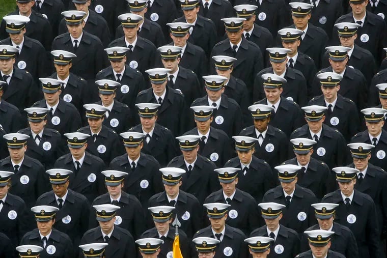 Navy midshipmen march onto field ahead of an NCAA college football game between the Army and the Navy in Philadelphia. A military investigation finds that hand gestures used by cadets and midshipmen during the Army-Navy game broadcast had nothing to do with white supremacy. The investigation, which included interviews and background checks, determined that two freshmen were taking part in a “sophomoric” game that had “no racist intent.”