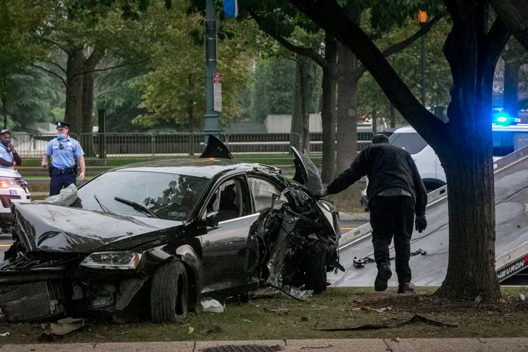 A police tow truck operator works to remove a Volkswagen Jetta involved in a fatal accident on the Benjamin Franklin Parkway, near 20th Street, in Philadelphia on Friday morning,