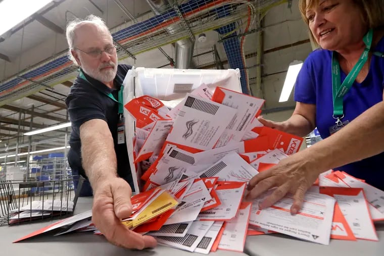 Election workers Mark Bezanson, left, and Julie Olson dump ballots collected earlier in the day from drop boxes onto a table for sorting at the King County Elections office, Monday, Nov. 5, 2018, in Renton, Wash. Voters in Washington all vote only by mail.