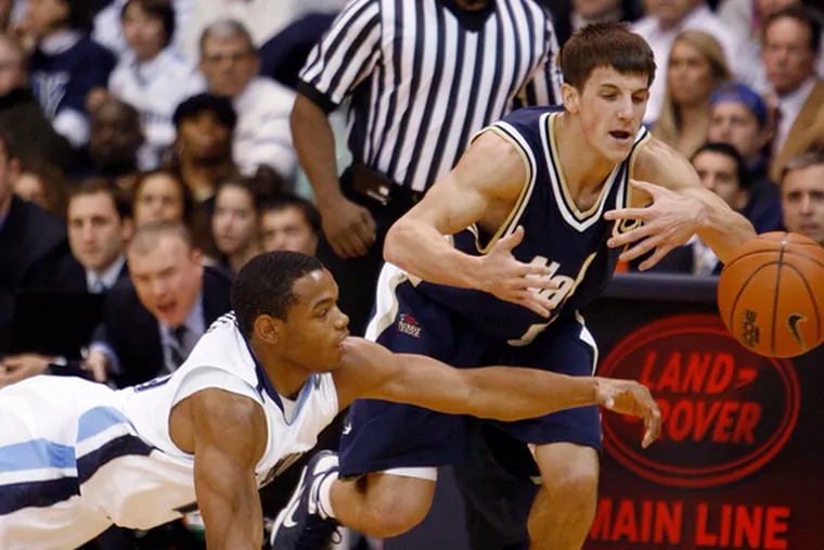 Villanova&#0039;s Corey Fisher (left), Navy&#0039;s Chris Harris reach for a loose ball in the first half of the Wildcats&#0039; win.