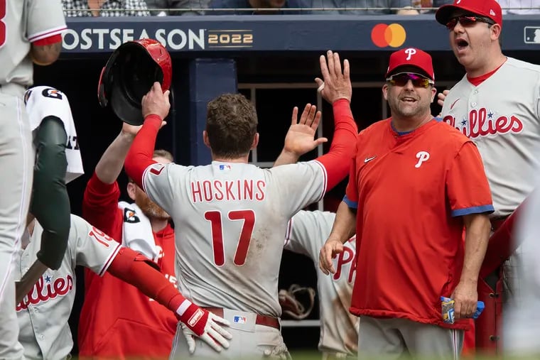 Rhys Hoskins is congratulated in the dugout after scoring a run in the first inning of Game 1 against the Atlanta Braves.