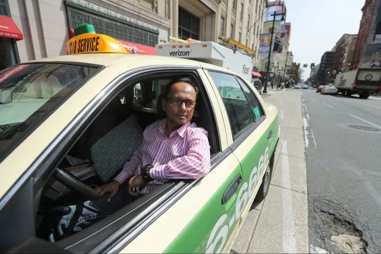 Shah Golamkade, a cab driver who switched to Uber and back to cab driving, is ready for a fare at Eighth and Market Streets.