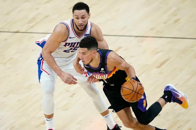 Phoenix Suns guard Devin Booker drives past Sixers guard Ben Simmons (25) during the second half Sunday.