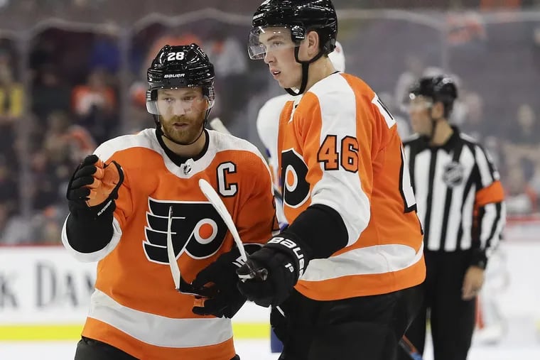 Flyers rookie center  Mikhail Vorobyev (right) gets some instruction from captain Claude Giroux during a preseason game Monday.