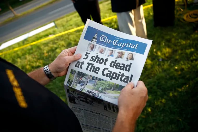 Steve Schuh, county executive of Anne Arundel County, holds a copy of The Capital Gazette. A man armed with smoke grenades and a shotgun attacked journalists in the newspaper's building on Thursday, killing five people.