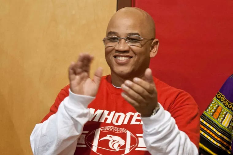 Imhotep coach Albie Crosby cheers during a pep rally Thursday at the school. RON TARVER / Staff Photographer