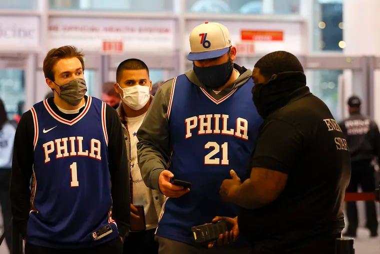 Masked Sixers fans get their tickets checked before entering the Wells Fargo Center before the Sixers play the Toronto Raptors in game two of the Eastern Conference quarterfinals playoffs on Monday, April 18, 2022 in Philadelphia.  The City of Philadelphia reinstated the indoor mask mandate beginning today.