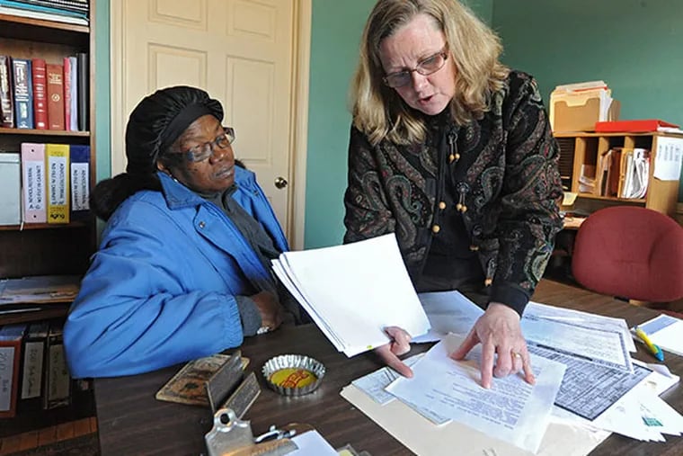 Niki Ludt, a Face to Face Legal Center director, searches through papers in a folder trying to help Gloria Cuttino, 62, get a birth certificate on March 18, 2014.  ( CLEM MURRAY / Staff Photographer )