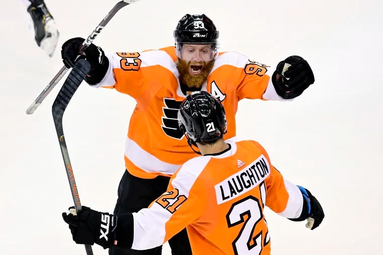 Flyers right winger Jakub Voracek (93) and teammate Scott Laughton (21) celebrate their team's overtime win Tuesday over the Islanders. Laughton redirected a shot past Semyon Varlamov for the 4-3 victory, keeping the Flyers' season alive..