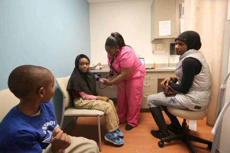 Kamaal Goodmond-Clark, 5, watches as medical assistant Tyesha Hightower, 27, takes the blood pressure of his sister Makyla-Zanabb, 9, with their mother, Yasmeen Goodmond, 27, in attendance at the Stephen Klein Wellness Center in North Philadelphia.
