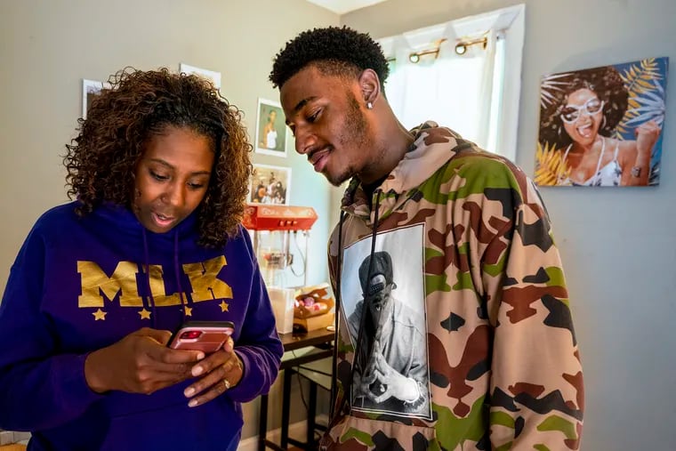 Karlynne Staten and her son Amir look at videos at their Germantown home Sunday, Feb. 26, 2023. A video that Staten posted of her son learning he was accepted into Morehouse College has gone viral.