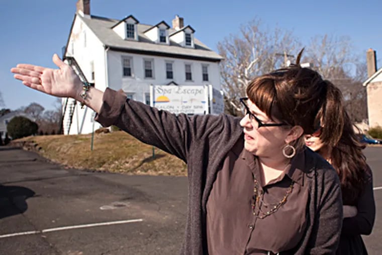 April Fox-Regan points to the close proximity of the proposed Wawa site (behind her) to Hatboro Borough Hall. With her is Heather Hamilton. (Ed Hille / Staff Photographer)