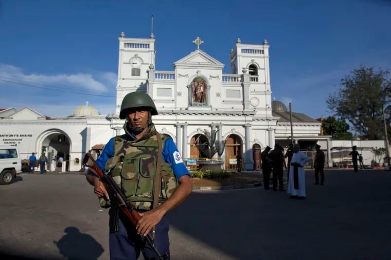 Sri Lankan air force officers and clergy stand outside St. Anthony's Shrine, a day after a blast in Colombo, Sri Lanka, Monday, April 22, 2019. Easter Sunday bombings of churches, luxury hotels and other sites was Sri Lanka's deadliest violence since a devastating civil war in the South Asian island nation ended a decade ago. (AP Photo/Gemunu Amarasinghe)