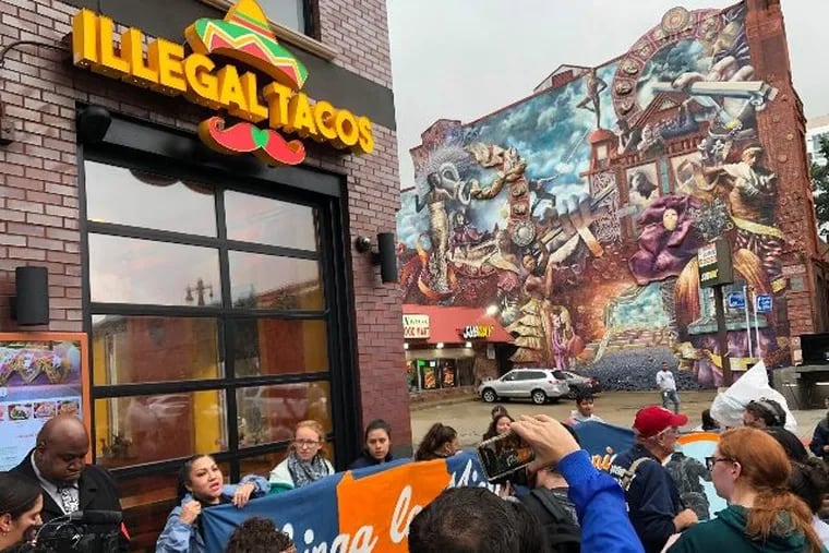Demonstrators mass outside the Illegal Tacos restaurant on South Broad Street on Tuesday.