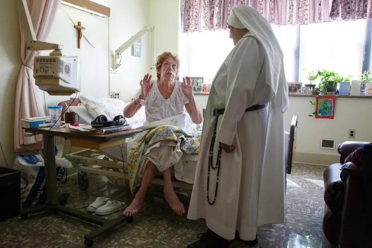 Patient Veronica Mardt, center, shares some of the details of her day with Sister Mary Augustine, at Sacred Heart Home in Northeast Philadelphia, Monday, Sept. 11, 2017. The nuns take care of terminally ill patients at the Sacred Heart Home. JESSICA GRIFFIN / Staff Photographer