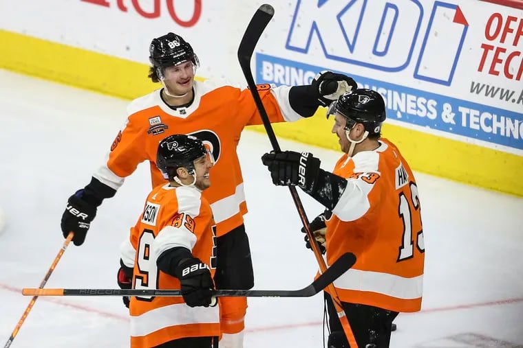 Flyers center Kevin Hayes celebrates his goal Tuesday against the Flames with teammates Joel Farabee (86) and Cam Atkinson (89). Atkinson and Hayes played college hockey together at Boston College.