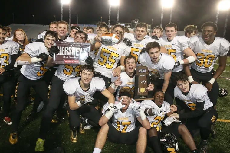 Archbishop Wood players celebrate with championship trophy after beating Cheltenham 19-15 to win the PIAA 5A State Championship in Hershey on Friday night.