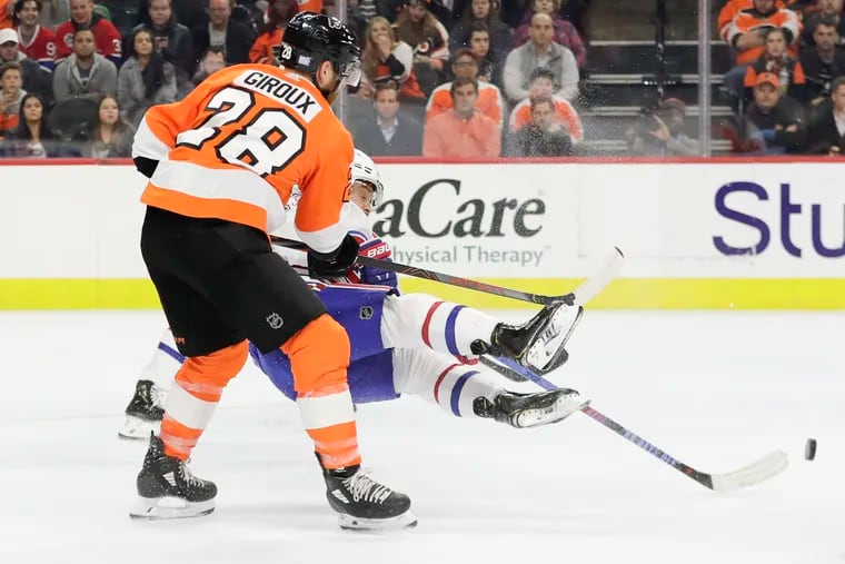 Montreal Canadiens center Max Domi falls down as the Flyers' Claude Giroux moves in during the third period.
