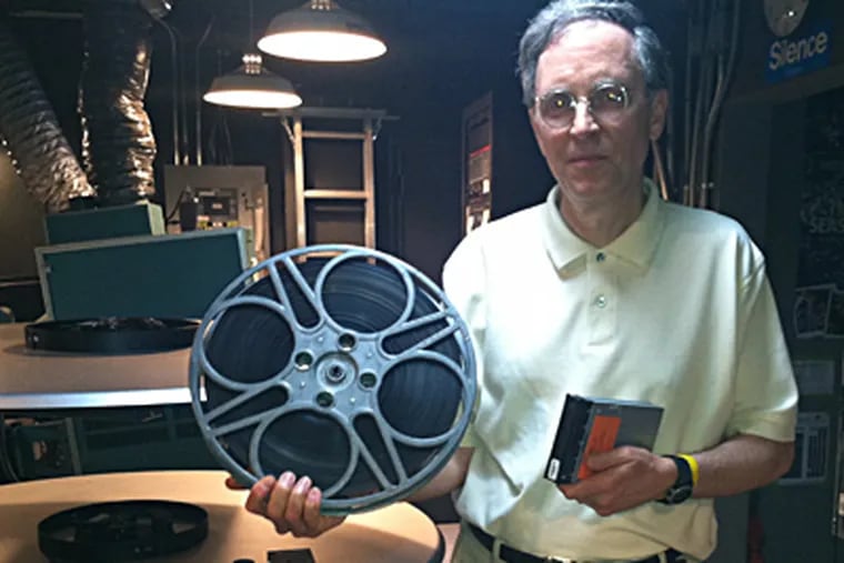 John Toner, executive director of Doylestown’s County Theater, with a reel of 35 mm film and a hard drive with a full-length digital movie. BILL REED / Staff