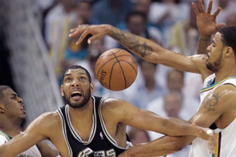 The San Antonio Spurs&#0039; Tim Duncan battles the New Orleans Hornets&#0039; Tyson Chandler (right) and Chris Paul for a loose ball. Duncan had 16 points and 14 rebounds.