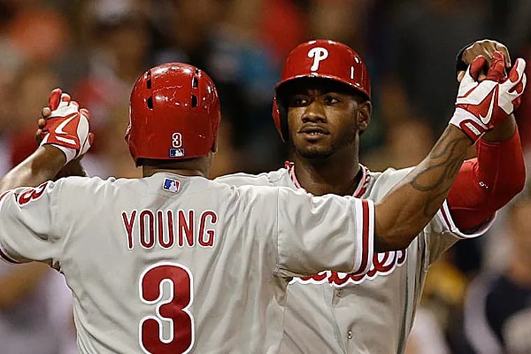 The Phillies' Domonic Brown and teammate Delmon Young celebrate Young's two-run home against the Padres in the eighth inning. (Gregory Bull/AP)