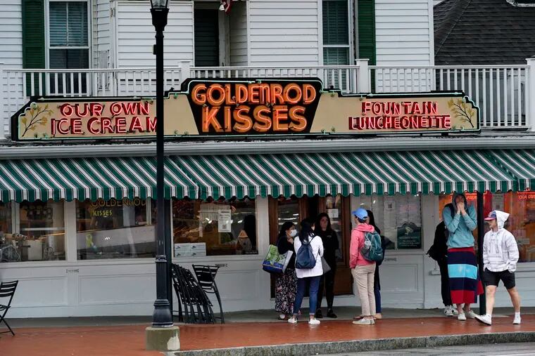 High school students gather outside The Goldenrod, a popular restaurant and candy shop, Wednesday, June 1, 2022, in York Beach, Maine. Many seasonal businesses are struggling to find enough workers again this summer.