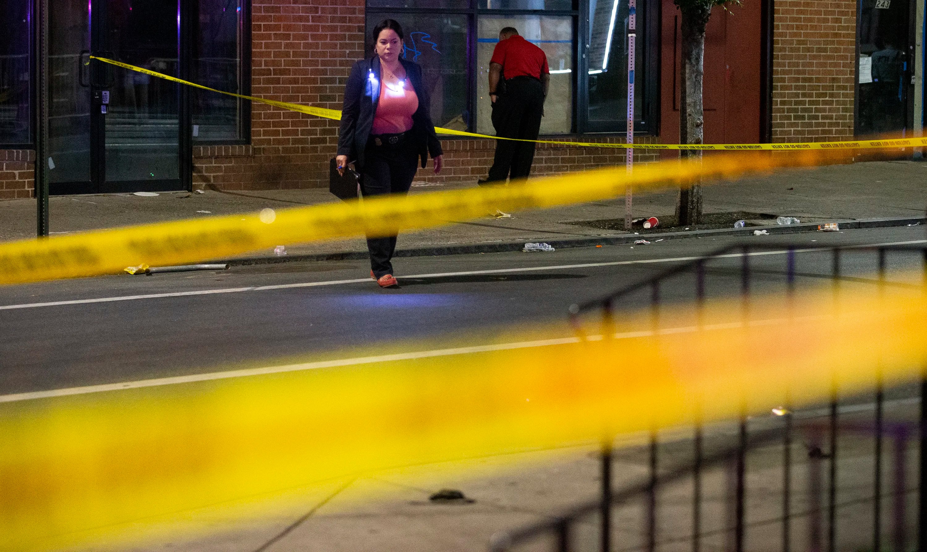 Philadelphia Police detectives look over the scene of a shooting on and near South Street that left 3 dead and 11 wounded.