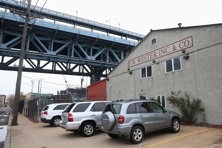 The F.W. Winter building is pictured under the Ben Franklin Bridge in Camden. Some local residents oppose the proposed erection of a 16-story digital billboard on the site by Interstate Outdoor Advertising CEO Drew Katz. 