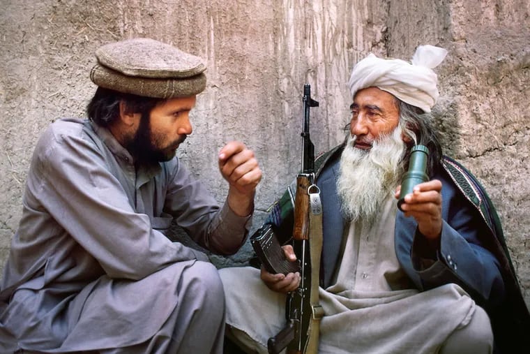 Photographer Steve McCurry (left) in a 1982 self-portrait with an Afghan man. The Michener exhibit spans the Darby native's 40-year focus on the country.