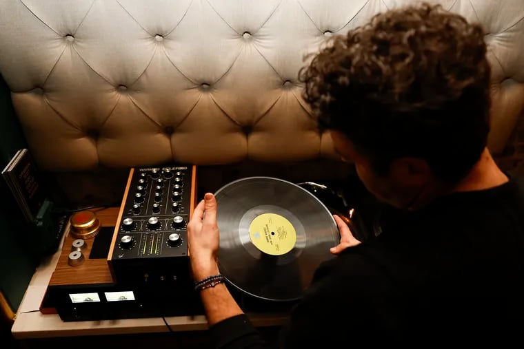 Noah Marmar, also known as “DJ On Mars,” prepares to play a vinyl record at the 48 Record Bar, a vinyl-centric cocktail bar in Old City.