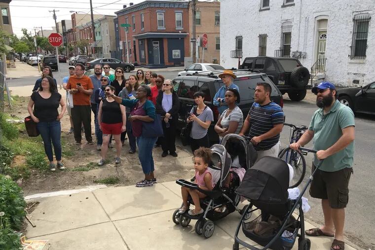 Philadelphians participate in Jane's Walk 2018, pausing on a block in Point Breeze.