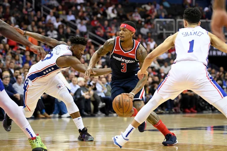 Washington Wizards guard Bradley Beal (3) dribbles the ball between Philadelphia 76ers guard Landry Shamet (1) and guard Jimmy Butler (23) during the second half of an NBA basketball game, Wednesday, Jan. 9, 2019, in Washington. The Wizards won 123-106. (AP Photo/Nick Wass)