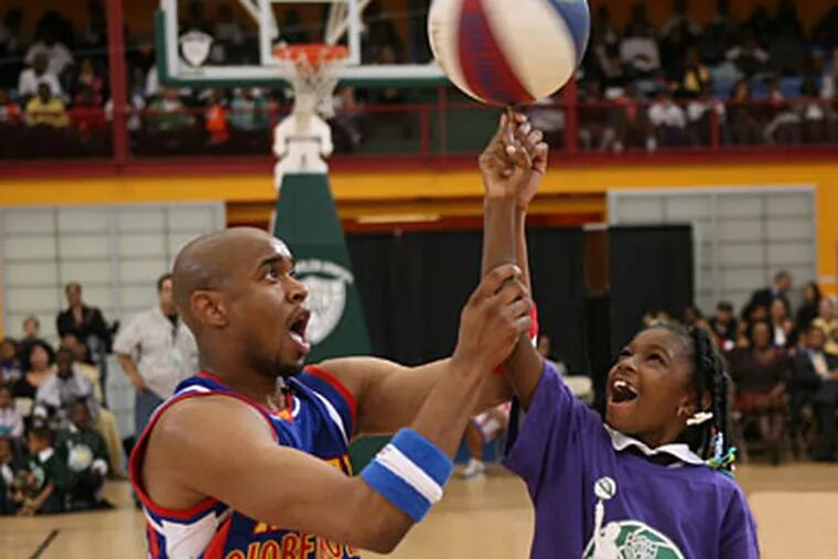 Scooter Christensen of the Harlem Globetrotters shows a young fan how to spin the ball on her finger. (Photo courtesy of the Harlem Globetrotters)