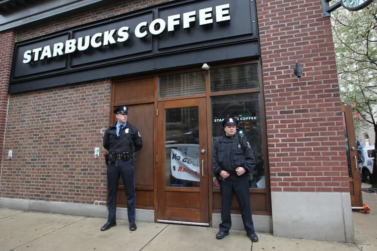 Police stand outside Starbucks at 18th and Spruce Streets, in Philadelphia, on Monday, April 16, 2018. At the time, demonstrators were inside protesting the arrests of two black men. JESSICA GRIFFIN / Staff Photographer