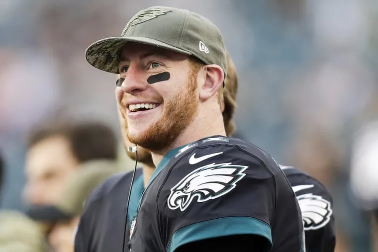 Eagles quarterback Carson Wentz smiles while on the sidelines during Sunday’s win over the Broncos.