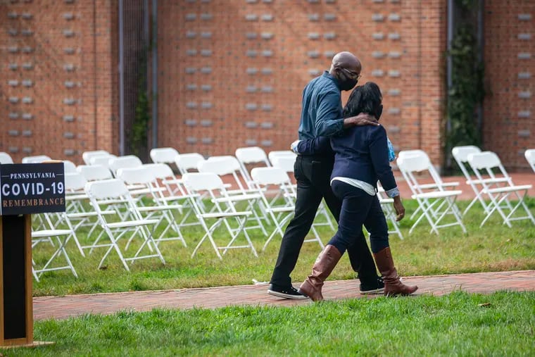 Carol Lewis and her brother Jeff Green walk away from a podium on Independence Mall in October after sharing the story their father, Hiram Green, who died of COVID-19 at 86.