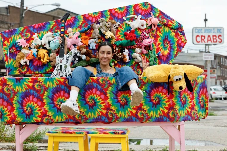 South Philly artist Rose Luardo sits in her latest guerrilla art project, the tie-dye "Rave Coffin," at the triangular cement lot between Washington Avenue, Passyunk Avenue, and Eighth Street in South Philly.