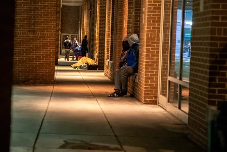 Homeless people rest up and settle in along the sidewalks on 12th Street on Wednesday, Dec. 18, 2019.