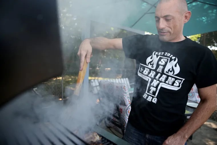 Brian Wiggins, owner of Saint Brian's Premium BBQ sauce, grills at his home in Philadelphia on June 28, 2017.
