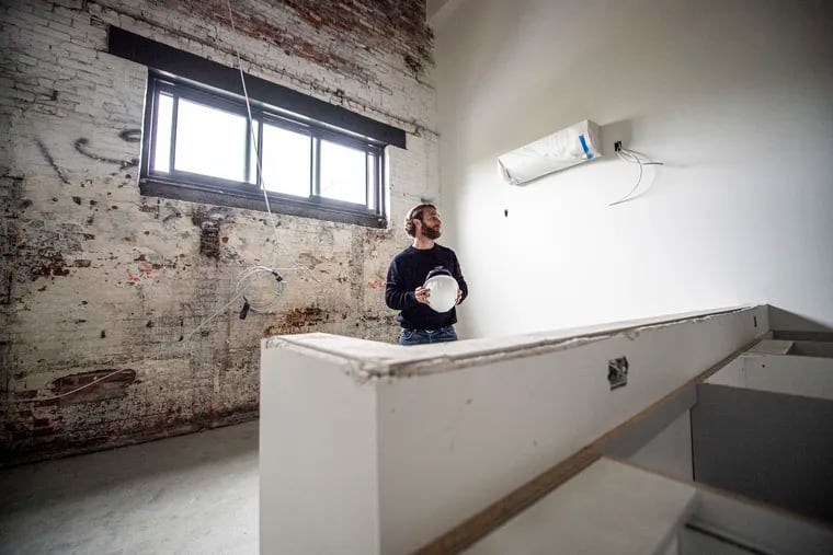 Aaron Smith, partner at MMPartners LLC, shows the finish on an exposed-brick wall of an apartment under construction at the Poth Brewery building in November 2021, in Philadelphia's Brewerytown section. The Poth Brewery Lofts has started leasing apartments at the former brewery.