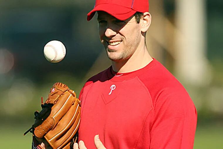 Cliff Lee tosses the ball around while warming up at Bright House Field in Clearwater.  (Yong Kim/Staff Photographer)