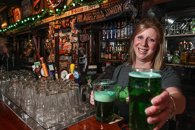 McGillin's bartender Tammy Zakreshi offers a green beer, Monday, March 11, 2014.  (  Steven M. Falk / Staff Photographer )